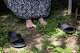 Diane Shields places her bare feet on the ground in her backyard before rocking on a large swing she uses to watch birds in Fort Worth, April 10, 2026. “It feels good to touch nature, doesn’t it?” she said.