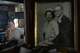 Scott Wheeler is reflected in a mirror as he looks at a photo of his late parents in his Dallas apartment, April 11, 2026. Wheeler’s home is filled with vintage records, family and 60s era political memorabilia. He pays $675 a month in rent and is worried the building will be redeveloped, pricing him out and potentially making him homeless.