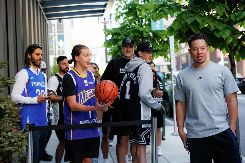 San Antonio Spurs head coach Mitch Johnson, right, stands next to Spurs fans looking for autographs outside of the team hotel on an off day during a first-round NBA playoff series against the Portland Trail Blazers, Saturday, April 25, 2026, in Portland, Ore. The Spurs face the Trail Blazers in Game 4 on Sunday afternoon.