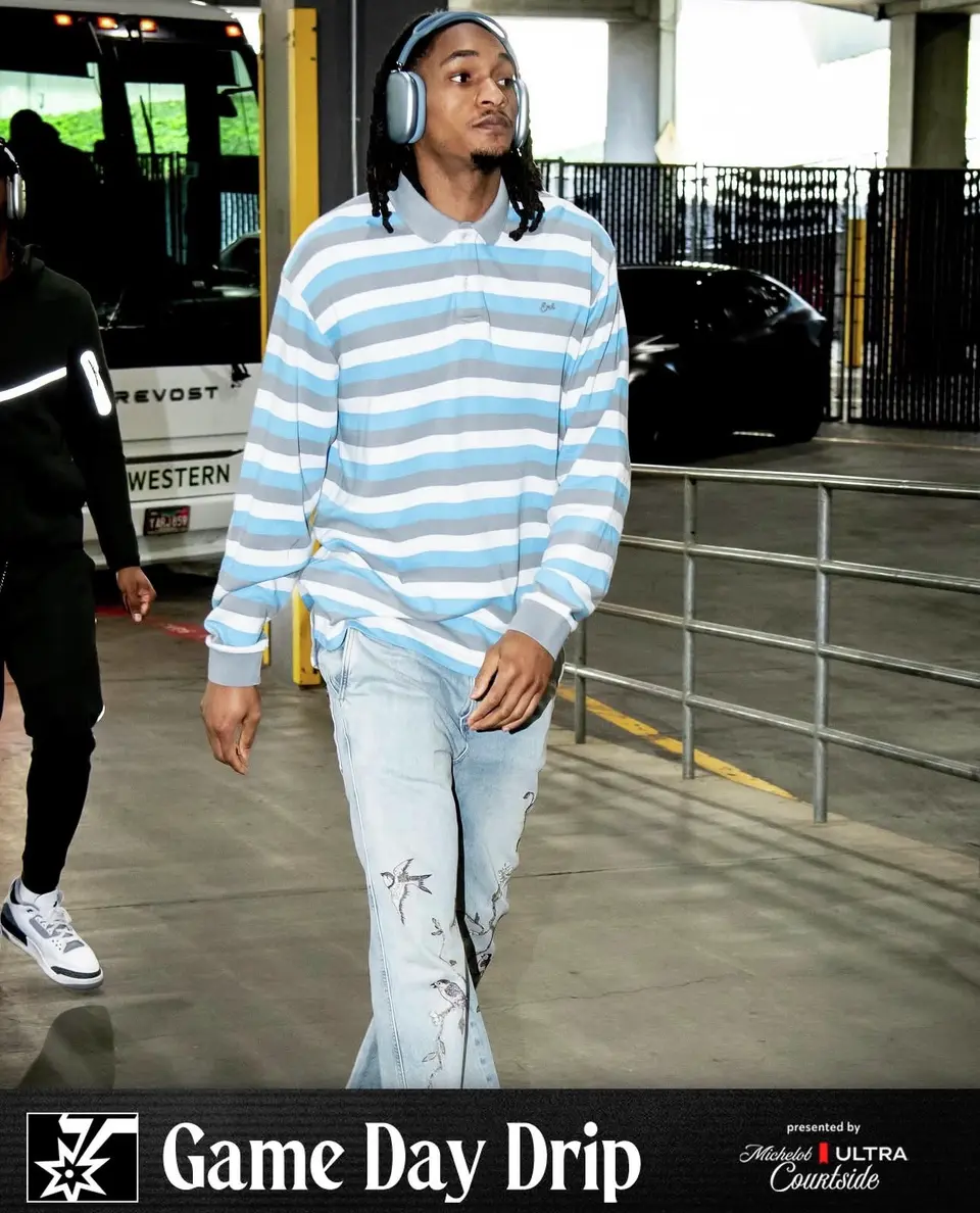 Devin Vassell keeps it polished and relaxed in an ERL gray and blue striped long-sleeve polo with light-wash embroidered denim and headphones.