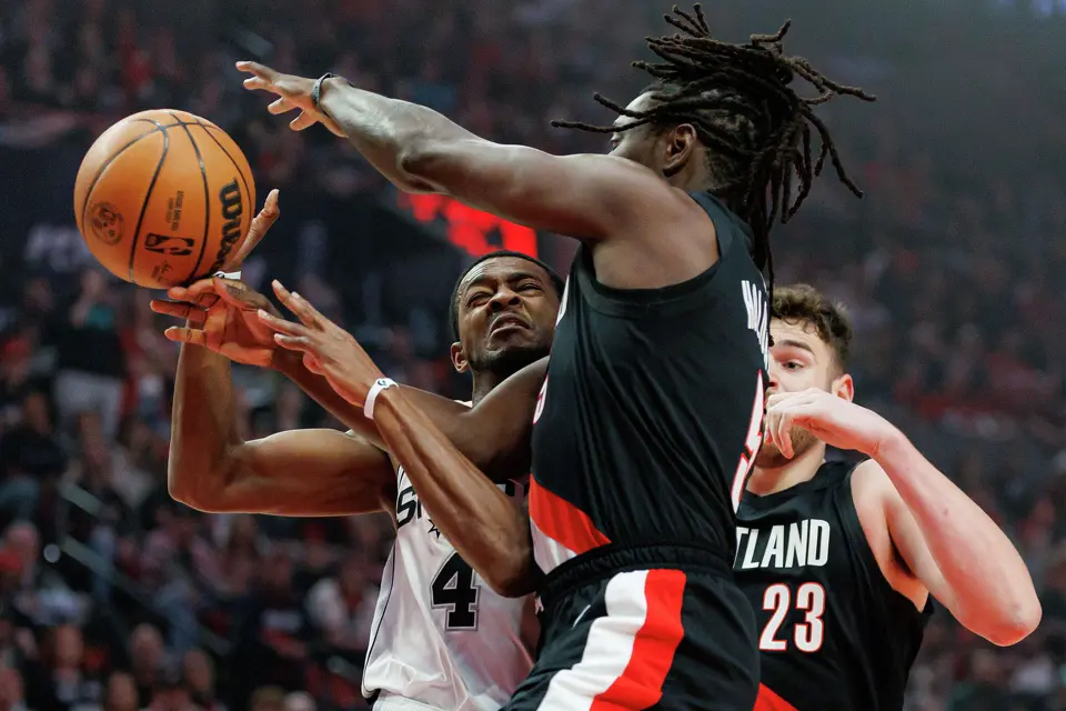 Portland Trail Blazers guard Jrue Holiday (5) makes down a shot from San Antonio Spurs guard De'aaron Fox (4) under the basket during the first quarter of Game 4 of a first-round NBA playoff series at Moda Center on Sunday, April 26, 2026.