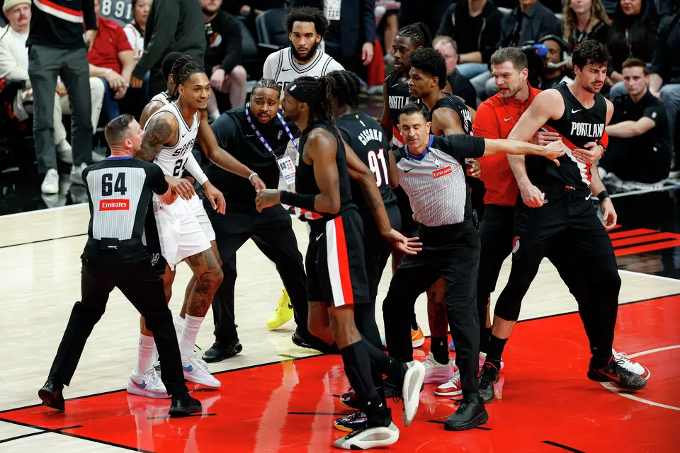 Players and staff swarm the court after a fight broke out between Portland Trail Blazers forward Deni Avdija (8) and San Antonio Spurs guard Stephon Castle (5) during the fourth quarter of Game 4 of a first-round NBA playoff series at Moda Center on Sunday, April 26, 2026. Castle and Avdija both received technical fouls. The Spurs won 114-93, leading the series 3-1.Players
