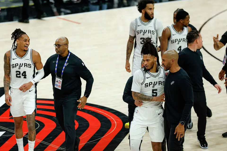 San Antonio Spurs guard Devin Vassell (24) smiles as he and San Antonio Spurs guard Stephon Castle (5) are escorted to the bench after a fight broke out between Portland Trail Blazers forward Deni Avdija (8) and Castle during the fourth quarter of Game 4 of a first-round NBA playoff series at Moda Center on Sunday, April 26, 2026. Castle and Avdija both received technical fouls. The Spurs won 114-93, leading the series 3-1.Players