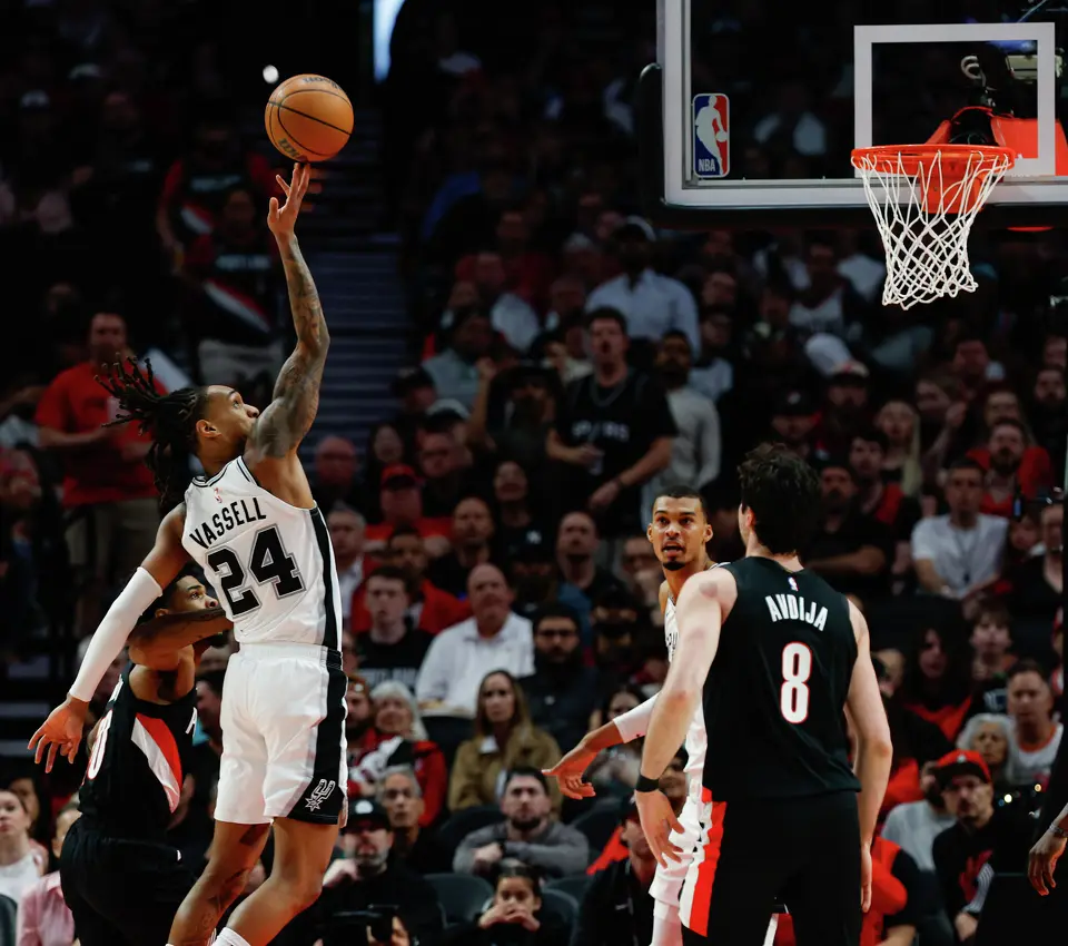 San Antonio Spurs guard Devin Vassell (24) pushes the ball backwards towards guard De'aaron Fox (4), not pictured, during the third quarter of Game 4 of a first-round NBA playoff series at Moda Center on Sunday, April 26, 2026.