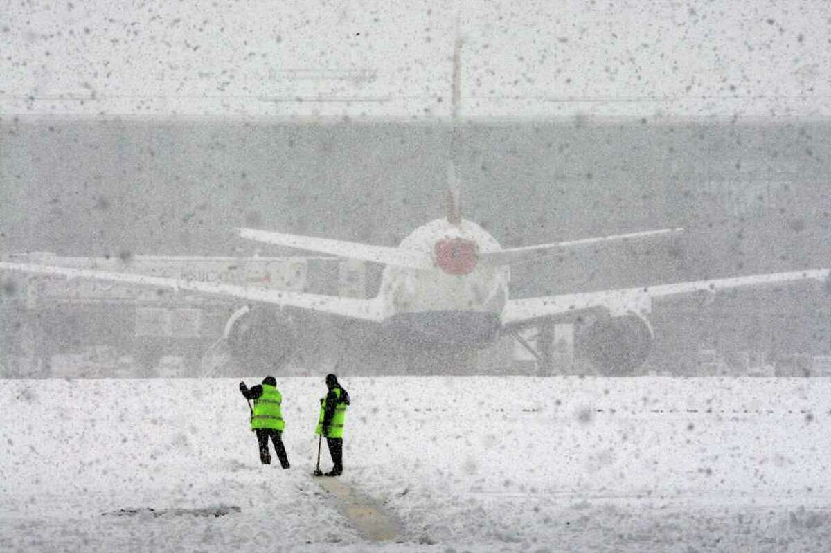 Workers try to clear the snow at London's Heathrow Airport, after all flights at the airport were grounded Saturday Dec. 18 2010. Britain's transport network ground to a halt Saturday as the country's major airports closed their runways on what is traditionally the busiest weekend before Christmas. Millions of people hoping to make an early getaway also faced travel misery on the nation's roads and railways as the big chill returned with a vengeance.(AP Photo/ Steve Parsons/PA)