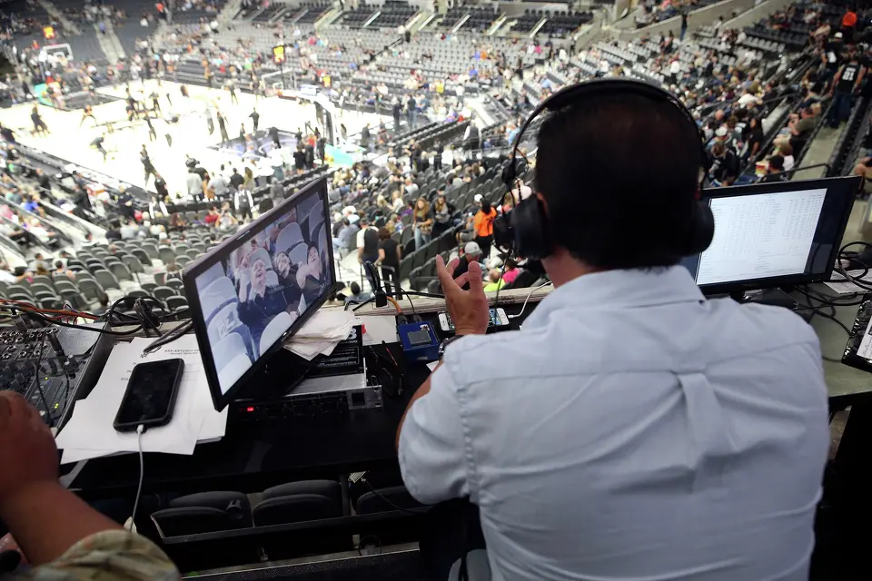 Radio broadcaster Paul Castro goes on the air from his perch above the arena as the Spurs host the Phoenix Suns at the AT&T Center on October 20, 2015.