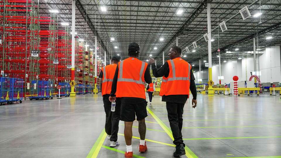 Employees walk through a new receive center during its opening day of distribution operations in Houston on Wednesday, April 29, 2026.