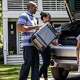 Excited family packing the back of the car for a summer road trip. Check out local vacation rentals like Airbnb.
