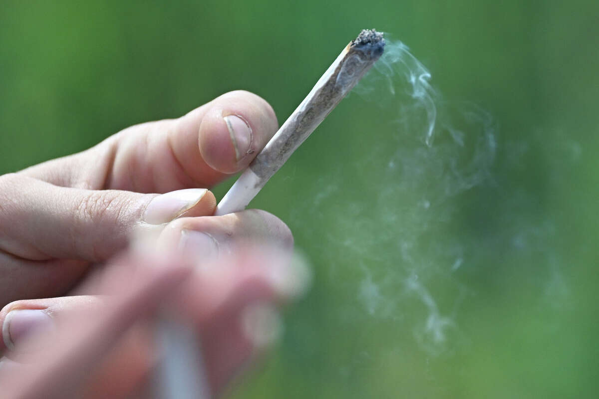 A participant in the annual Hemp Parade (Hanfparade), a demonstration in support of of hemp, smokes a joint in Berlin on August 9, 2025. (Photo by RALF HIRSCHBERGER / AFP) (Photo by RALF HIRSCHBERGER/AFP via Getty Images)
