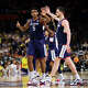 INDIANAPOLIS, INDIANA - APRIL 06: Tarris Reed Jr. #5 of the UConn Huskies high fives teammate Alex Karaban #11 during the first half against the Michigan Wolverines in the National Championship of the 2026 NCAA Men's Basketball Tournament at Lucas Oil Stadium.