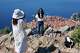 Tourists take photos of themselves on a hill overlooking the old town of Dubrovnik, Croatia, Monday, April 27, 2026.