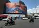 Vehículos circulan junto a una valla publicitaria con una imagen del estrecho de Ormuz y los labios cosidos del presidente estadounidense Donald Trump, en una plaza del centro de Teherán, Irán, el sábado 2 de mayo de 2026. (Foto AP/Vahid Salemi)