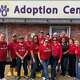 Group of people in red t-shirts in front of Halo Adoption Center.