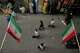 People walk as Iranian flags hang in the Grand Bazaar in Tehran, Sunday, May 3, 2026.