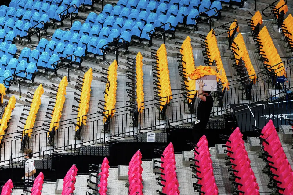 A worker carries extra fiesta-themed T-shirts through the arena before Game 1 of the Western Conference semifinals between the San Antonio Spurs and the Minnesota Timberwolves at Frost Bank Center in San Antonio on Monday, May 4, 2026.