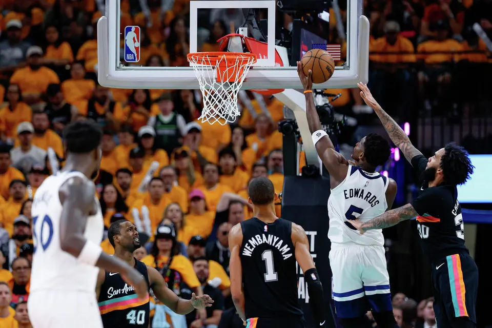 Minnesota Timberwolves guard Anthony Edwards (5) makes a shot in between San Antonio Spurs forward Victor Wembanyama (1) and forward Julian Champagnie (30) during the second half of Game 1 of the Western Conference semifinals at Frost Bank Center in San Antonio, Monday, May 4, 2026. The Spurs fell 104-102 to the Timberwolves.