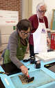 Artist Bill Pangburn watches Doris Cheng ink her lino cut during the Art Museum of Southeast Texas workshop, May 2.