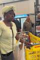 Trimica Smith, 53, gathers groceries during a visit to a North Texas food pantry ahead of Mother's Day. Smith said rising food costs and cuts to assistance benefits have forced her family to increasingly rely on community food resources.