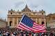 FILE - A flag from the United States waves in the crowd as Pope Leo XIV appears at the central balcony of St. Peter's Basilica for his first Sunday blessing after his election, in St. Peter's Square at the Vatican, Sunday, May 11, 2025.