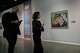 People visit an exhibition called: "Art & war" displaying some artworks of American pop artists as Roy Lichtenstein's "Brattata" is seen at right, at the Tehran Museum of Contemporary Art in Iran, Thursday, May 7, 2026.