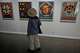 Iranian Artist Ghazaleh Jahanbin looks at screenprints of American artist Robert Indiana as she visits an exhibition called: "Art & war" displaying some artworks of American pop artists at the Tehran Museum of Contemporary Art in Iran, Thursday, May 7, 2026.