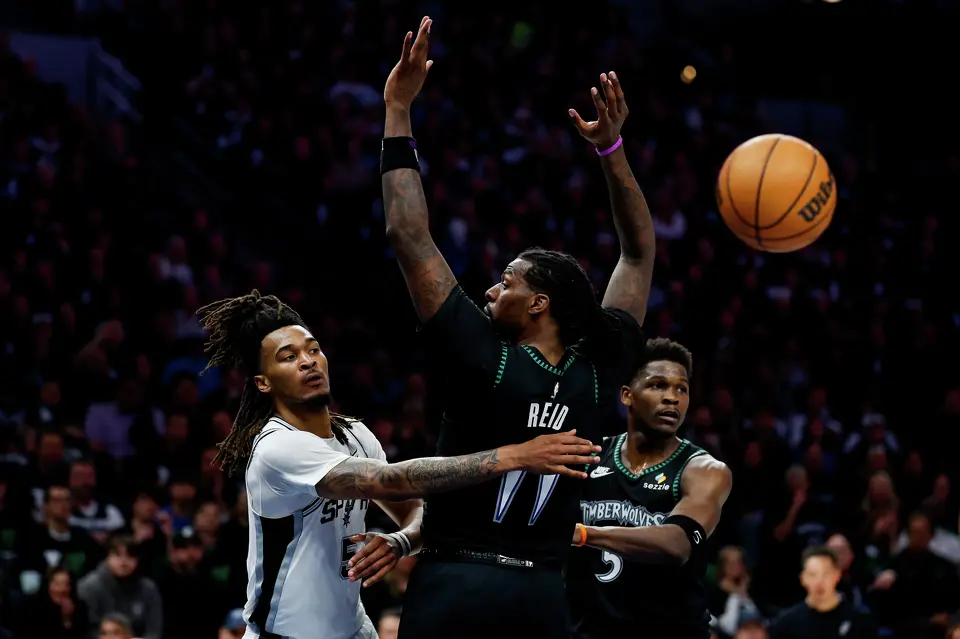 San Antonio Spurs guard Stephon Castle (5) makes a pass around Minnesota Timberwolves center Naz Reid (11) during the first half of Game 3 of the Western Conference semifinals at Target Center in Minneapolis, Friday, May 8, 2026.