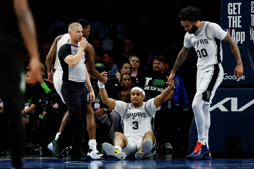 San Antonio Spurs forward Julian Champagnie (30) and San Antonio Spurs guard De'aaron Fox (4) help teammate San Antonio Spurs forward Keldon Johnson (3) off the ground during the second half of Game 3 of the Western Conference semifinals at Target Center in Minneapolis, Friday, May 8, 2026. The Spurs defeated the Timberwolves 115-108, leading the series 2-1.