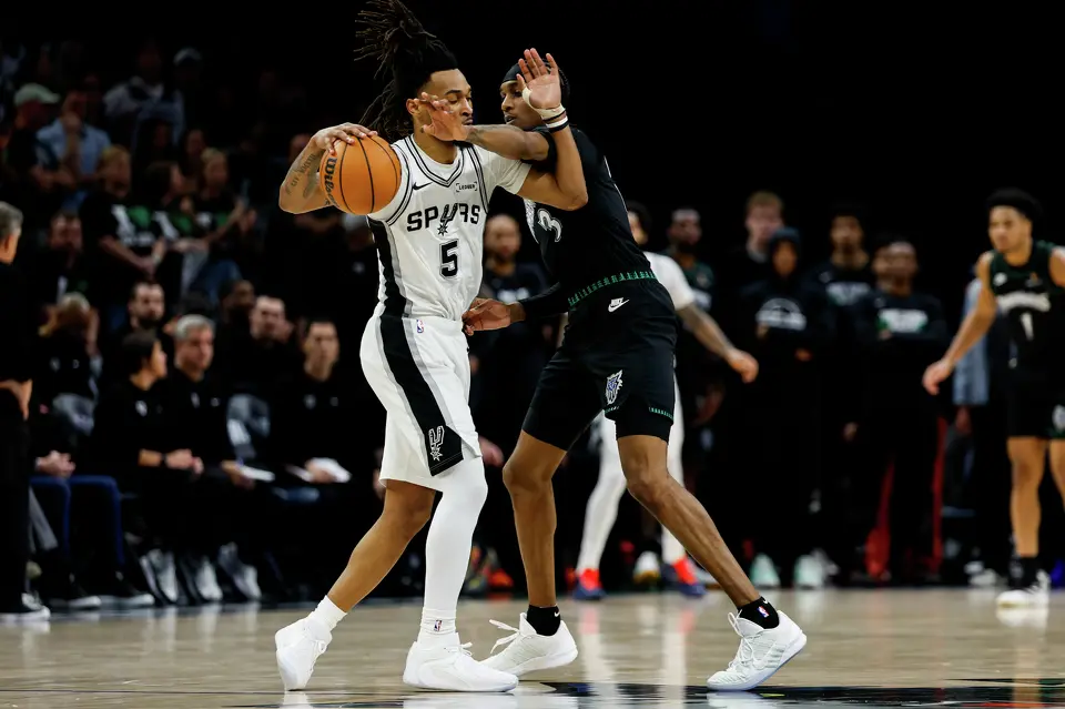 San Antonio Spurs guard Stephon Castle (5) dribbles the ball while guarded by Minnesota Timberwolves forward Jaden McDaniels (3) during the second half of Game 3 of the Western Conference semifinals at Target Center in Minneapolis, Friday, May 8, 2026. The Spurs defeated the Timberwolves 115-108, leading the series 2-1.