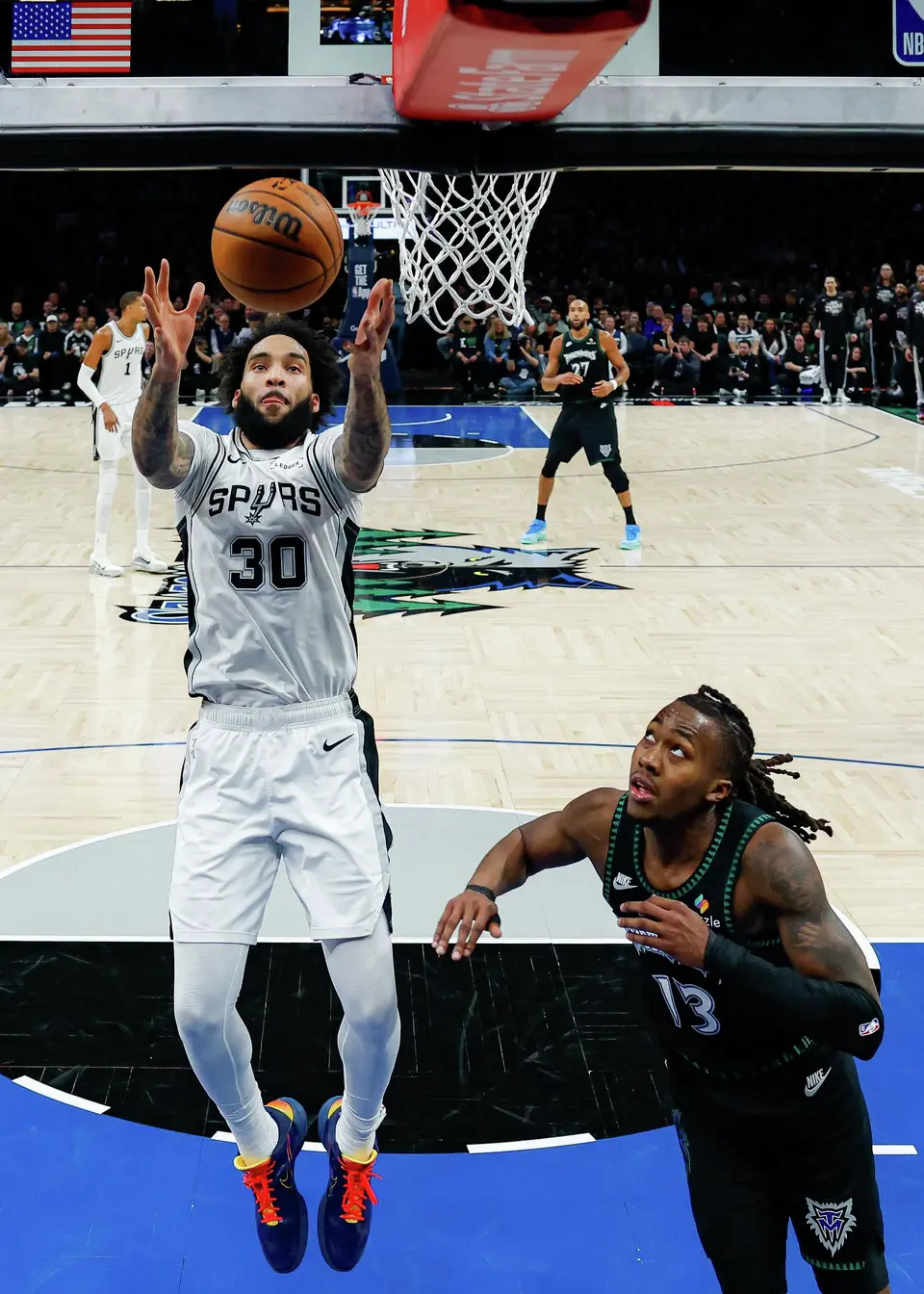 San Antonio Spurs forward Julian Champagnie (30) goes up for the rebound over Minnesota Timberwolves guard Ayo Dosunmu (13) during the second half of Game 3 of the Western Conference semifinals at Target Center in Minneapolis, Friday, May 8, 2026. The Spurs defeated the Timberwolves 115-108, leading the series 2-1.