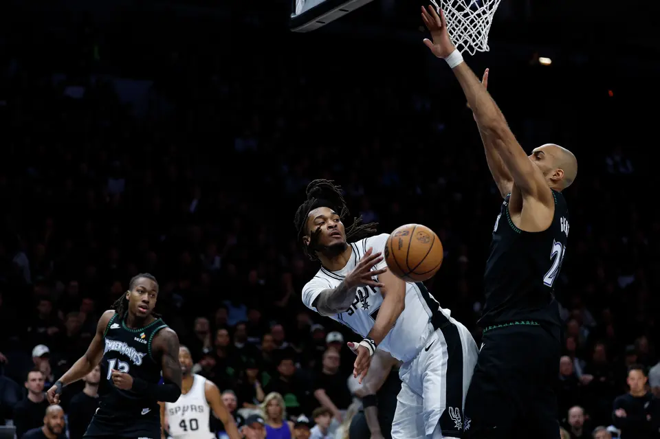 San Antonio Spurs guard Stephon Castle (5) makes a pass underneath Minnesota Timberwolves center Rudy Gobert (27) during the first half of Game 4 of the Western Conference semifinals at Target Center in Minneapolis on Sunday, May 10, 2026.