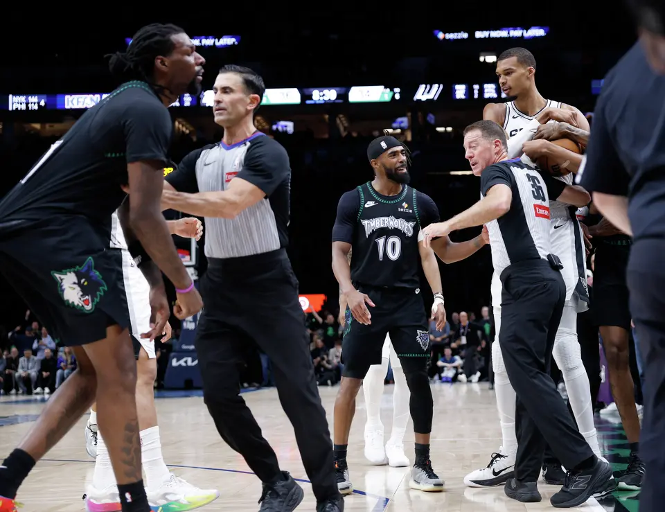 Referees separate San Antonio Spurs center Victor Wembanyama (1), right, after throwing an elbow at Minnesota Timberwolves center Naz Reid (11), left, leading to Wembanyama’s ejection in the 2nd quarter of Game 4.