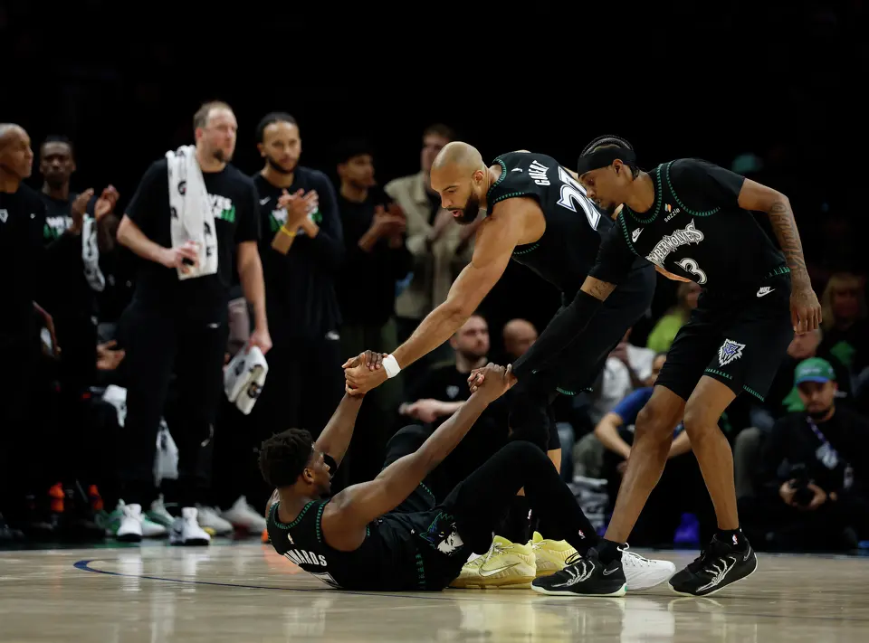 Minnesota Timberwolves guard Anthony Edwards (5) is helped up by teammates Minnesota Timberwolves center Rudy Gobert (27) and forward Jaden McDaniels (3)during the first half of Game 4 of the Western Conference semifinals at Target Center in Minneapolis on Sunday, May 10, 2026.