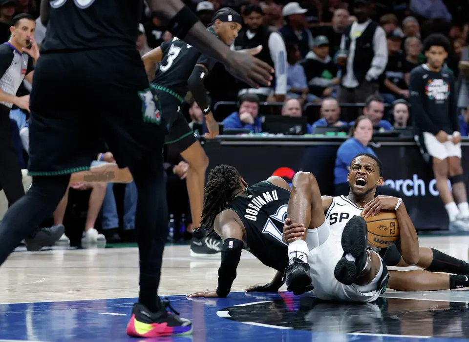 San Antonio Spurs guard De'Aaron Fox (4) grabs his ankle after a collision with Minnesota Timberwolves guard Ayo Dosunmu (13)during the second half of Game 4 of the Western Conference semifinals at Target Center in Minneapolis on Sunday, May 10, 2026. The Spurs lost to the Timberwolves 114-109, tying the series at 2-2.