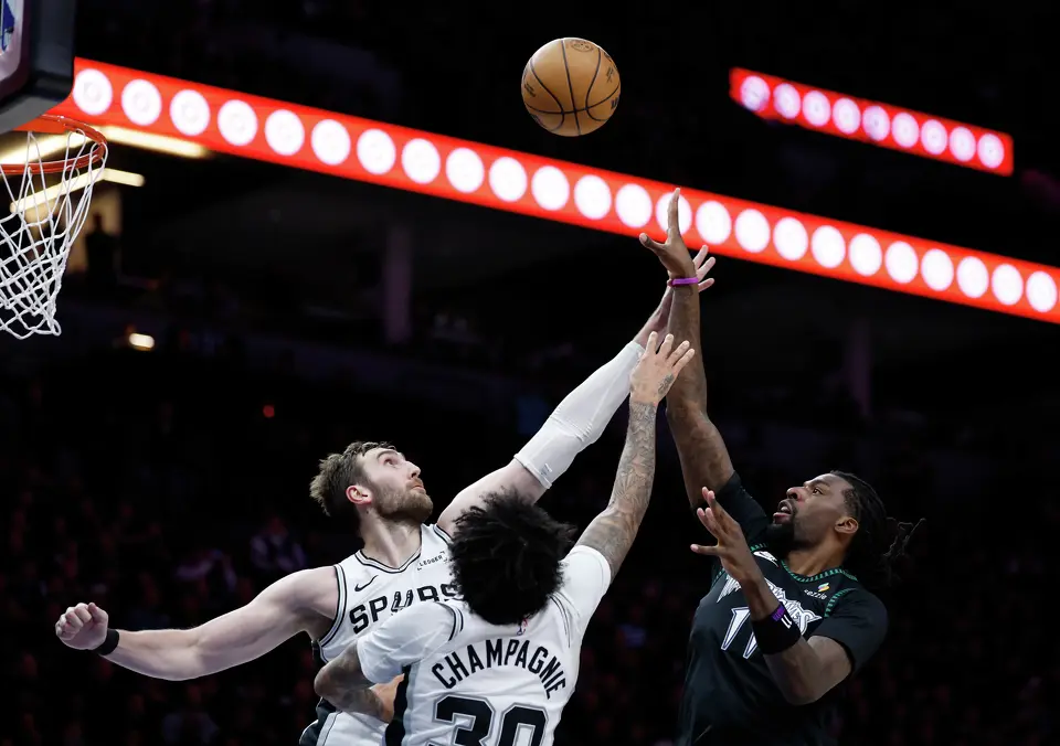 Minnesota Timberwolves center Naz Reid (11) gets the ball past San Antonio Spurs center Luke Kornet (7) and forward Julian Champagnie (30)during the second half of Game 4 of the Western Conference semifinals at Target Center in Minneapolis on Sunday, May 10, 2026. The Spurs lost to the Timberwolves 114-109, tying the series at 2-2.