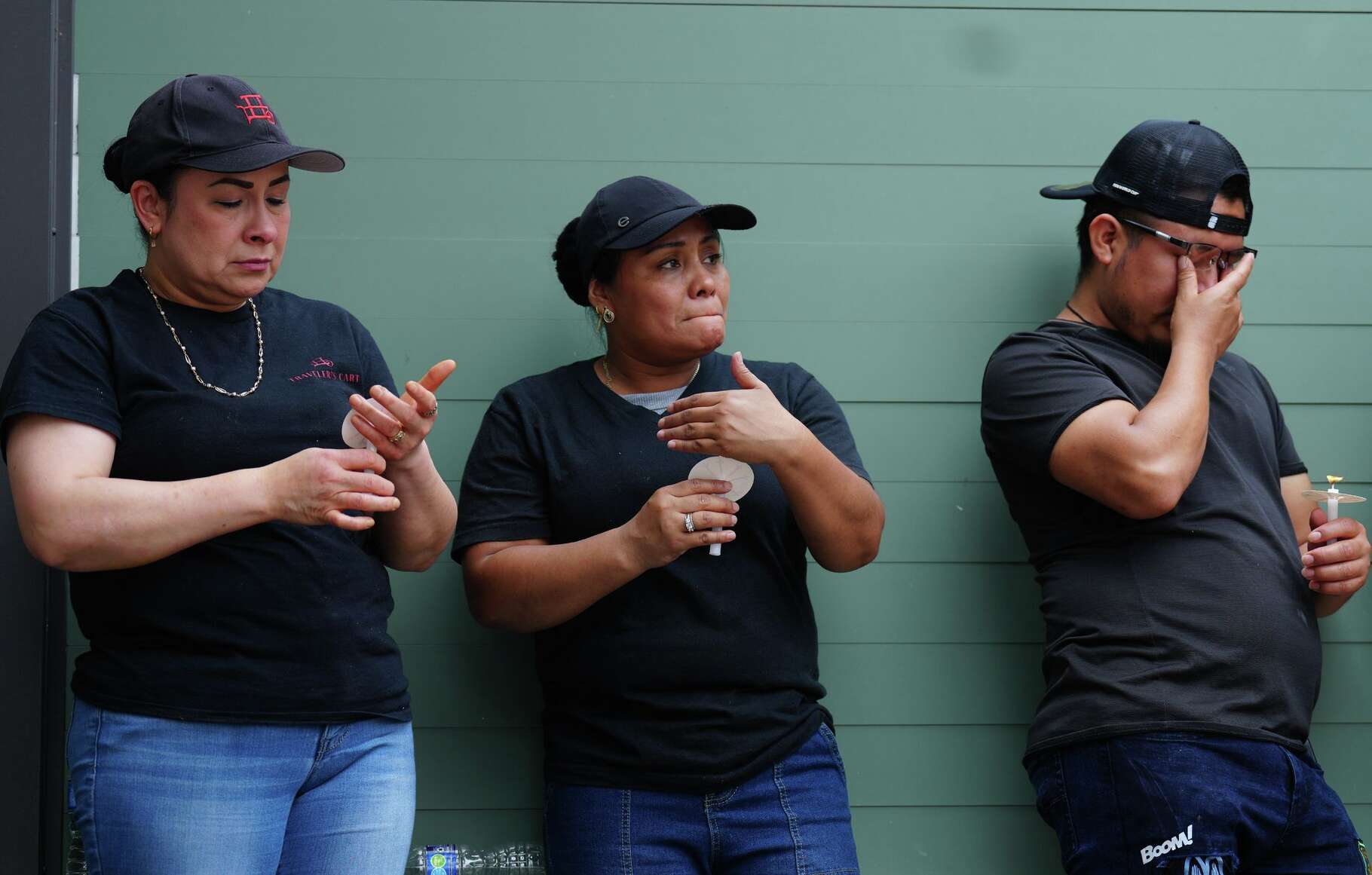 Employees at Traveler’s Cart take a moment during a vigil for owner Thy Mitchell and her children in Houston on Monday, May 11, 2026.