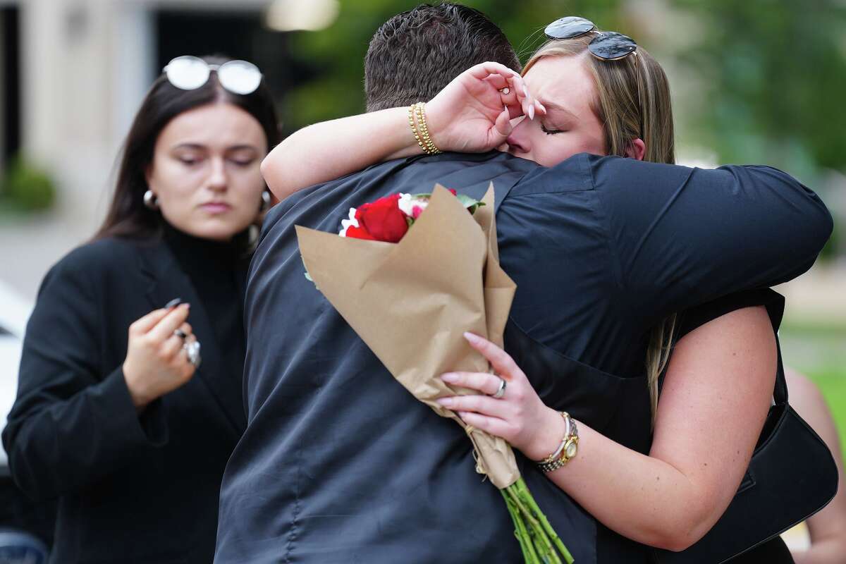 Friends and colleauges comfort each other at Traveler’s Cart for vigil for Thy Mitchell and her children in Houston on Monday, May 11, 2026.