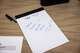 A notepad with a handwritten note is left on a sign-in table in council chambers during a Red Oak City Council meeting where council members voted on rezoning land.