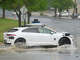 A Waymo autonomous vehicle goes through standing water on Metro Center Drive after a brief, intense rainstorm April 30 in Austin.