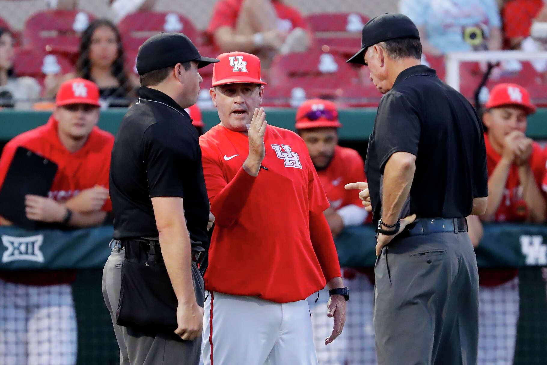 Houston head coach Todd Whitting, center, argues with umpires if a hit by Stephen F. Austin down the first base line was foul during an NCAA baseball game on Tuesday, March 25, 2025, in Houston. 