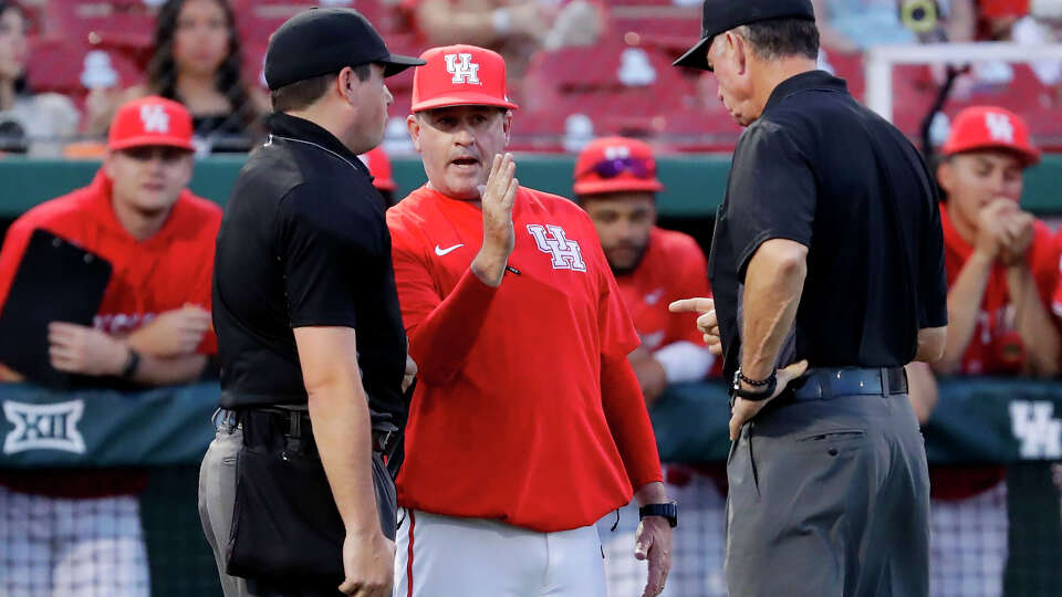 Houston head coach Todd Whitting, center, argues with umpires if a hit by Stephen F. Austin down the first base line was foul during an NCAA baseball game on Tuesday, March 25, 2025, in Houston. 