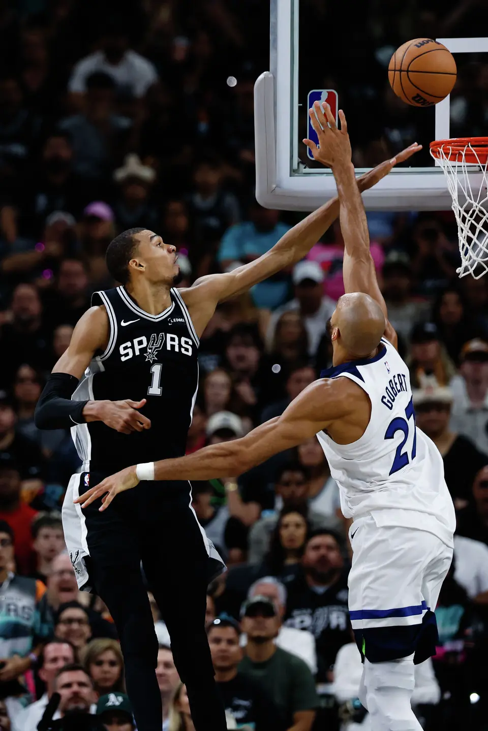 San Antonio Spurs forward Victor Wembanyama (1) and Minnesota Timberwolves center Rudy Gobert (27) reach for the ball during the first half of Game 5 of the Western Conference semifinals at Frost Bank Center in San Antonio, Tuesday, May 12, 2026.
