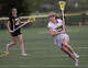 Hand's Claire Levis looks for an open teammate during a CIAC high school girls lacrosse match against Amity at Harold Strong Field in Madison, Conn., Thursday, April 30, 2026.