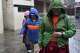 U.S.-born Buddhist lama Jalue Dorje walks in the rain with his parents, Dorje Tsegyal and Dechen Wangmo, during a 12-day series of rituals and teachings at Shechen Monastery in Kathmandu, Nepal, on Wednesday, April 8, 2026.