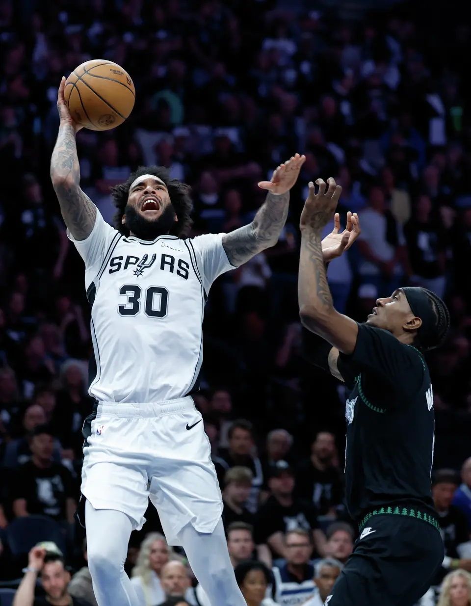 San Antonio Spurs forward Julian Champagnie (30) takes a shot over Minnesota Timberwolves forward Jaden McDaniels (3) during the first half of Game 6 of the Western Conference semifinals at Target Center in Minneapolis, Friday, May 15, 2026.