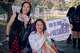 Kacie Chan, izquierda, sostiene sus nuevos obsequios y Mira Yoon sostiene un cartel que dice: “RM es nuestro presidente”.