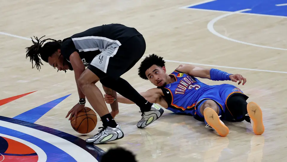 San Antonio Spurs guard Stephon Castle (5) grabs a loose ball from Oklahoma City Thunder guard Jared McCain (3) during the first half of Game 1 of the Western Conference Finals at Paycom Center in Oklahoma City, Monday, May 18, 2026.