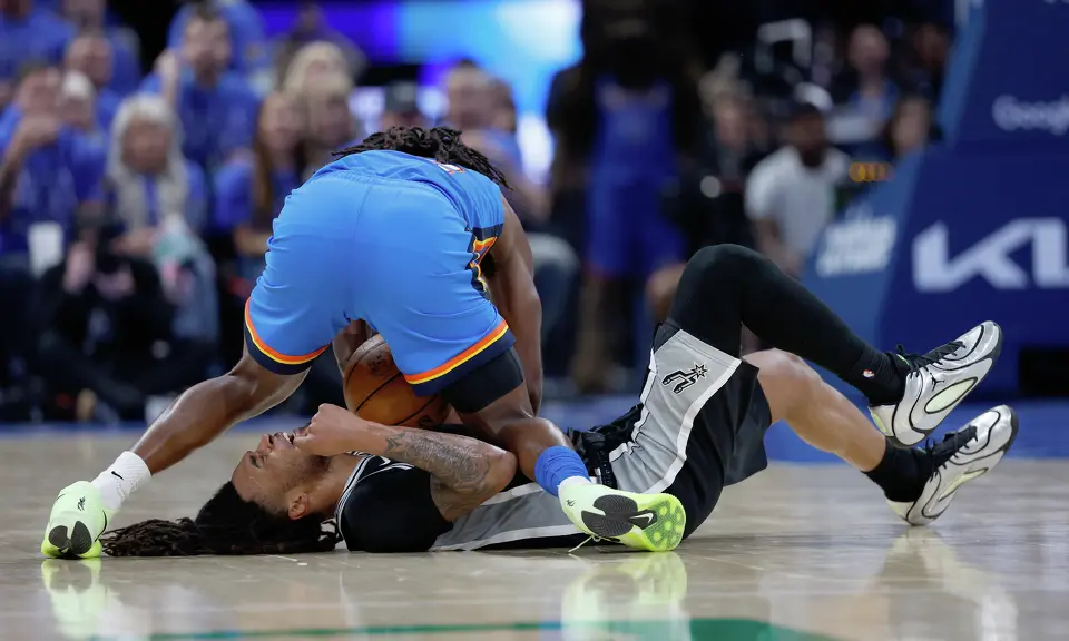 San Antonio Spurs guard Stephon Castle (5) grimaces as Oklahoma City Thunder guard Cason Wallace (22) lands on him while chasing a loose ball during the third quarter of Game 1 of the Western Conference Finals at Paycom Center in Oklahoma City, Monday, May 18, 2026.
