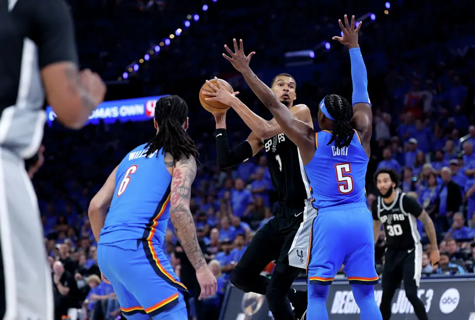 San Antonio Spurs forward Victor Wembanyama (1) looks to pass off the ball while being defended by Oklahoma City Thunder guard Luguentz Dort (5) during the third quarter of Game 1 of the Western Conference Finals at Paycom Center in Oklahoma City, Monday, May 18, 2026.