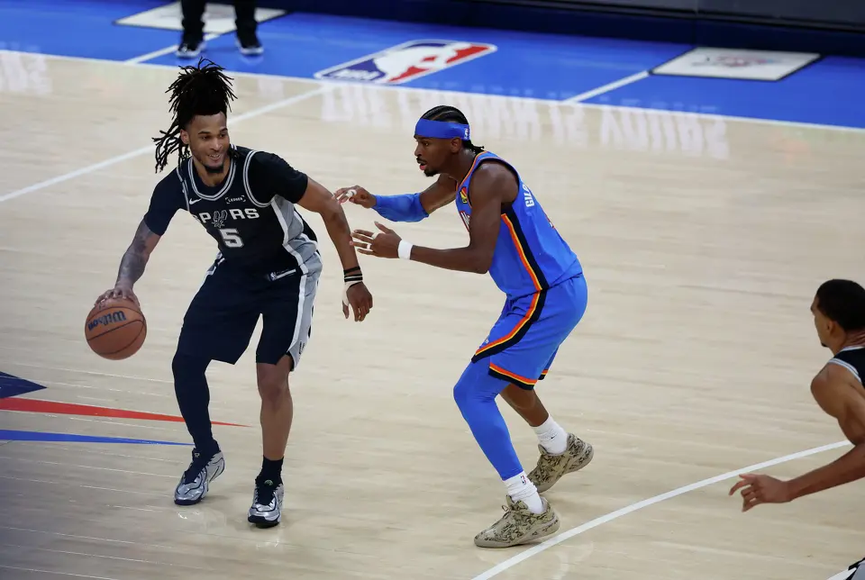 San Antonio Spurs guard Stephon Castle (5) brings the ball up the court with a smile as he’s guarded by Oklahoma City Thunder guard Shai Gilgeous-Alexander (2) during the second half of Game 1 of the Western Conference Finals at Paycom Center in Oklahoma City, Monday, May 18, 2026. The Spurs defeated the Thunder 122-115 in double overtime.