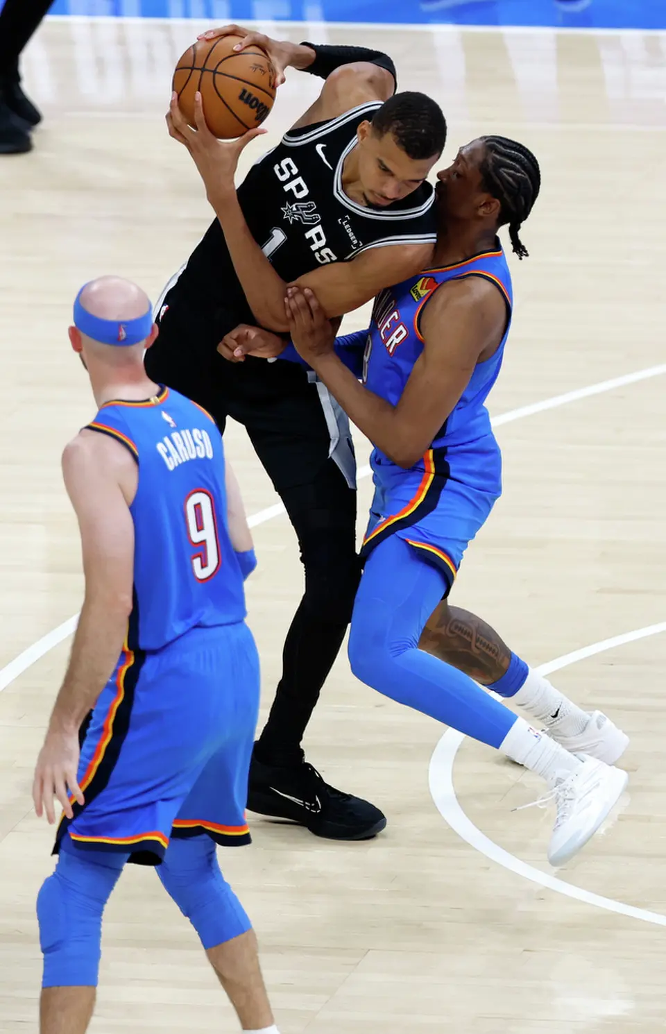 San Antonio Spurs forward Victor Wembanyama (1) leans a shoulder into Oklahoma City Thunder guard Shai Gilgeous-Alexander (2) while trying to drive to the hoop during the second half of Game 1 of the Western Conference Finals at Paycom Center in Oklahoma City, Monday, May 18, 2026. The Spurs defeated the Thunder 122-115 in double overtime.